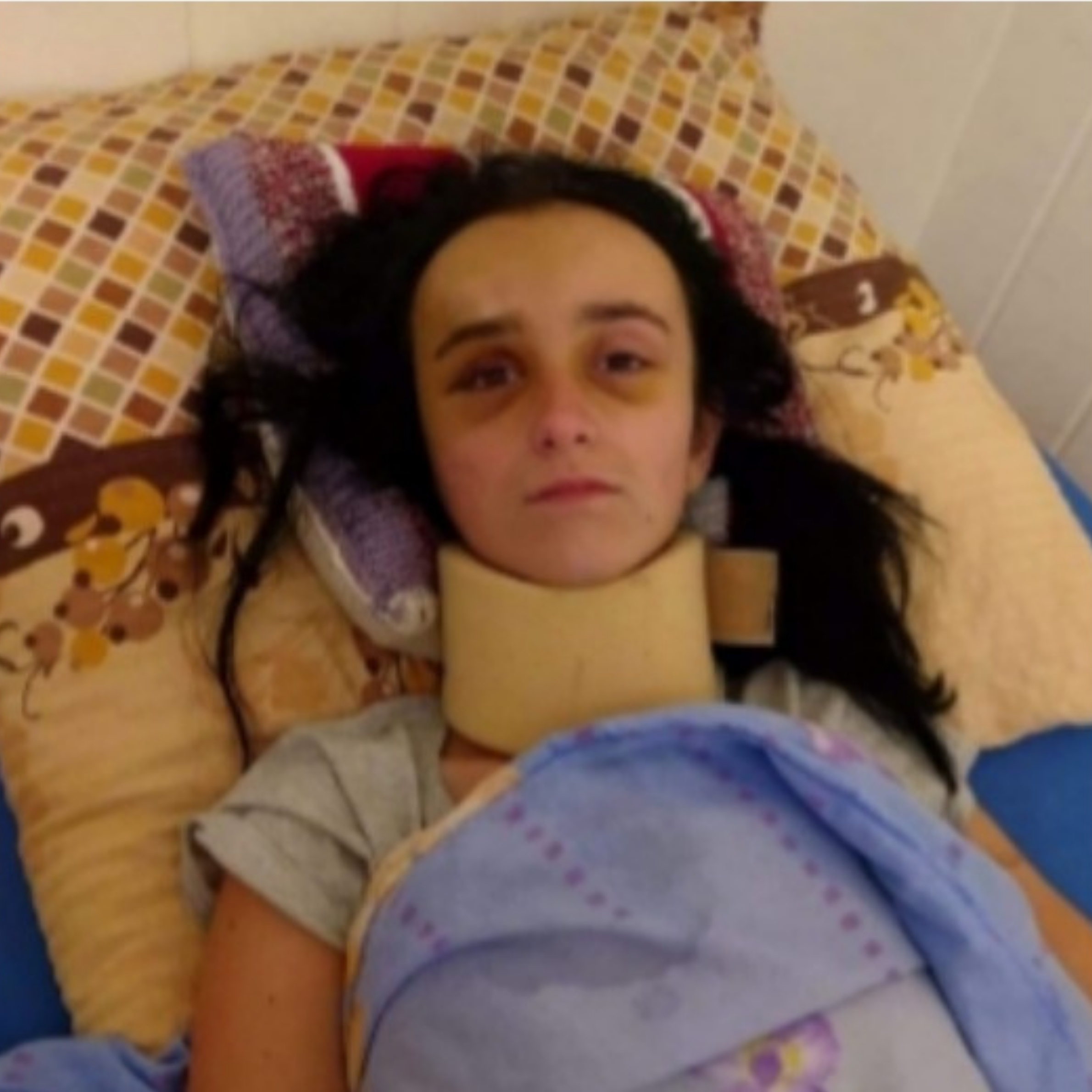 Emilia Bodziony leży w łóżku w kołnierzu ortopedycznym